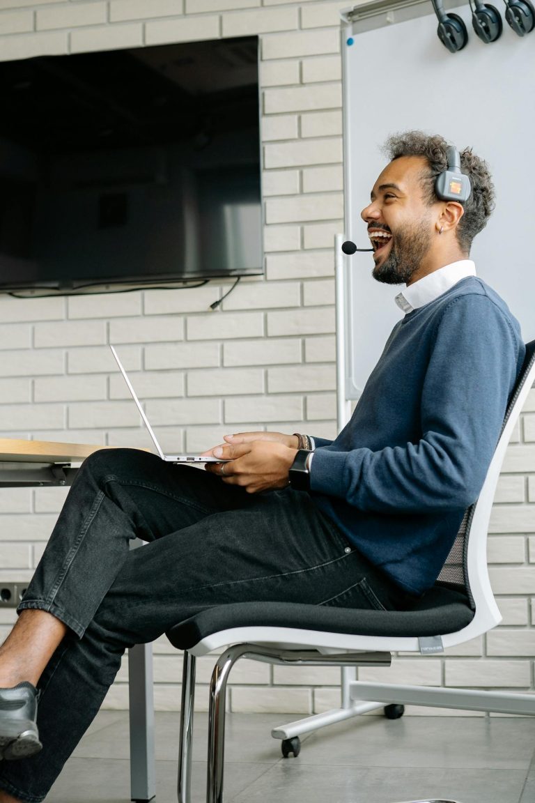 Man Laughing While Sitting on a Chair